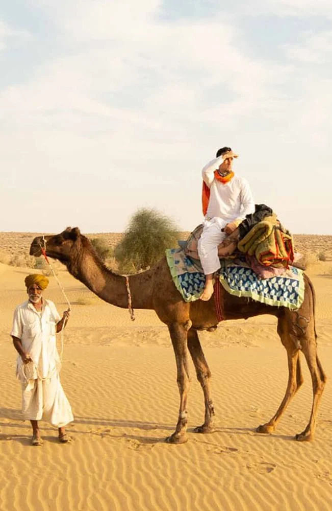 Camel safari silhouettes against the setting sun